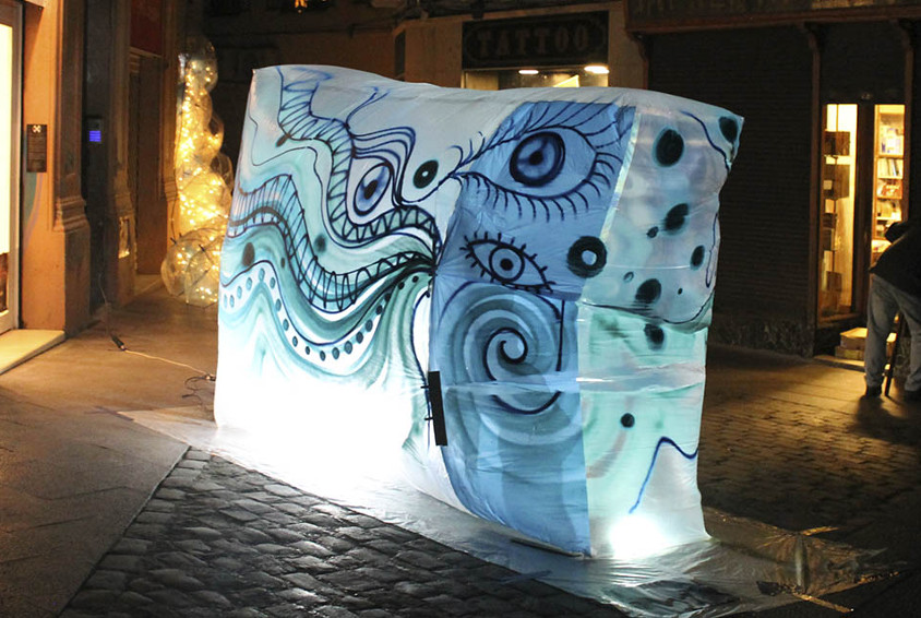Material plàstic decorat amb ulls de colors freds al mig del carrer