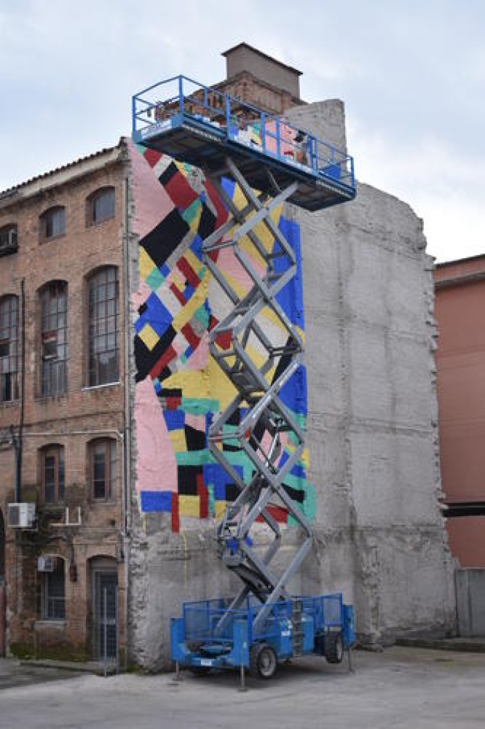 L'artista visual Berni Puig pinta un mural de grans dimensions a una paret de l'Anònima 